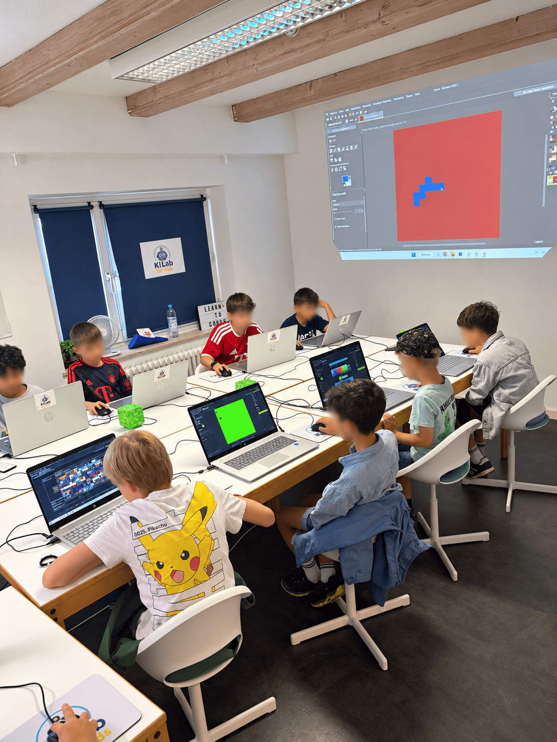 Kinder im KI Lab für Kids bei der Arbeit an Computern